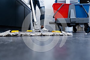 Low shot of cleaning lady mopping the floor in restroom photo