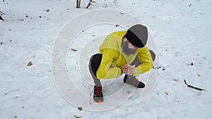 Low shot of male sports man warming up before running in winter forest