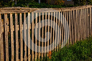 Low sunshine on a wooden fence and grass