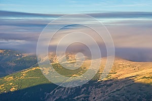 Low Tatras mountain ridge under mist during autumn sunrise, view from Skalka mountain