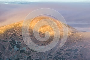 Low Tatras mountain ridge under mist during autumn sunrise, view from Skalka mountain