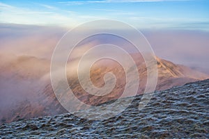 Low Tatras mountain ridge under mist during autumn sunrise, view from Skalka mountain