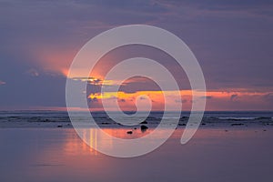 Low tide calm reef water at colorful island sunset