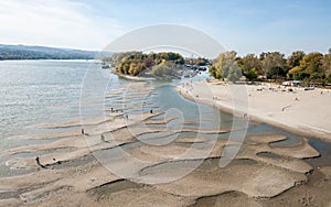 Low tide of the Danube river with people silhouettes walking on the sand islands left after water withdrawal in the Novi Sad, Serb