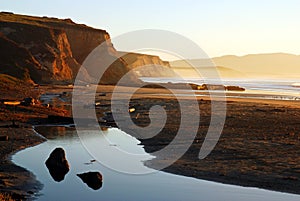 A low tide leaves pools near the beach cliffs