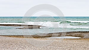 Low tide pools in the beach of Cubelles, Barcelona, Spain. Mediterranean Sea background