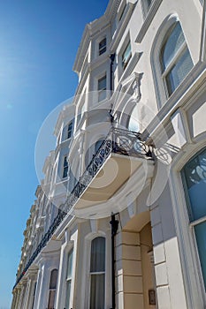 A low view point of a row of white English regency terraced four storey houses