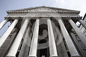 Low view of Royal Exchange with light blue sky, London, England, United Kingdom