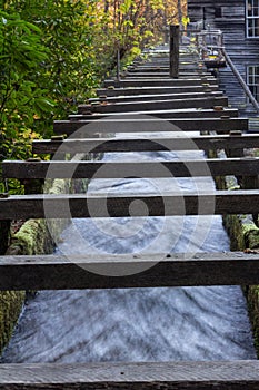 Low view of a wood walled sluice channeling water toward an old mill