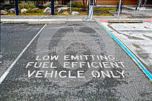 LowEmitting Fuel Efficient Vehicle only parking place with electric charging station by business- blacktop surface