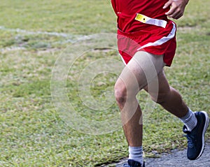 Lower body of a runner running race at a park