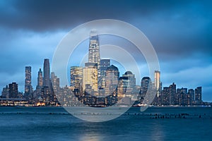 Lower Manhattan illuminated skyscrapers and storm clouds, New York City