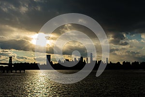 Lower Manhattan Skyline on the East River in New York City during Sunset with Skyscraper Silhouettes