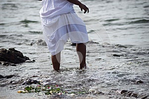 Lower part of the legs of unidentified people on the beach