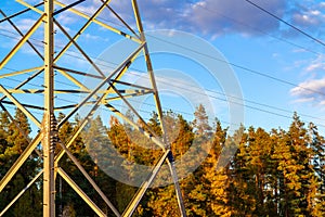 Lower part of the pylon against the background of the forest and blue sky