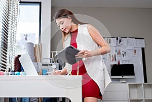 Lower view of professional designer or tailor woman use tablet and laptop to check order and communicate with customer in