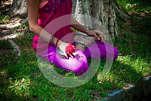 Lower woman body in lotus yoga posture outdoor practice in park