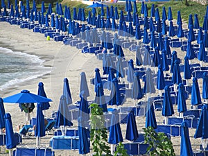 Lowered blue beach umbrellas. the concept of the end of the beach season