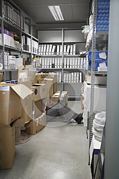 Lowsection Of Man With Laptop On Floor In Storage Room photo
