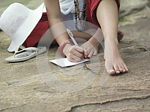 Lowsection Of Woman Writing On Paper Outdoors photo