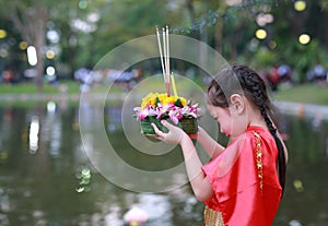 Loy Krathong festival, Asian Child girl in Thai traditional dress with holding krathong for forgiveness Goddess Ganges to