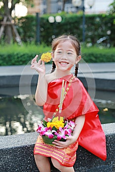 Loy Krathong festival, Asian Child girl in Thai traditional dress with holding krathong for forgiveness Goddess Ganges to