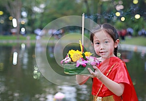 Loy Krathong festival, Asian Child girl in Thai traditional dress with holding krathong for forgiveness Goddess Ganges to celebrat