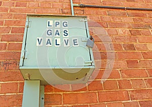 LPG gas valve container on a red brick wall