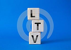 LTV - Life Time Value symbol. Concept word LTV on wooden cubes. Beautiful blue background. Business and LTV concept. Copy space