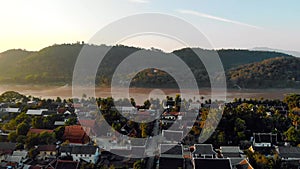 Luang Prabang, Laos. Aerial view Luang Prabang town in Laos. Cloudy sky over small city surrounded by mountains. Mekong