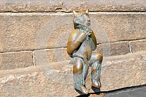 Lubeck. Bronze devil sitting on a stone banch outside St. Mary`s Church or Marienkirche photo