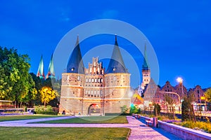 Lubeck, Germany - July 22, 2016: Tourists visit famous Holstentor gate on a summer night, Schleswig-Holstein, northern Germany