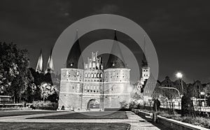 Lubeck, Germany - July 22, 2016: Tourists visit famous Holstentor gate on a summer night, Schleswig-Holstein, northern Germany