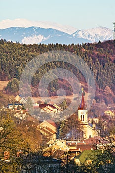 Obec Slovenská Lupča s kostelem a Nízkými Tatrami na obzoru