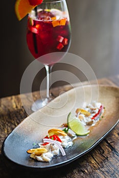 Lubina Ceviche with lime juice, shallots, a wedge of lime and fried garlic photo