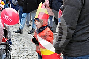 Little boy yawning at a celebration of St nicholas santa Claus nameday at `Orszak Swietego Mikolaja` Saint Nicholas Processio
