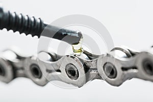 Lubricating a bicycle chain with a drop of oil close-up on an isolated gray background