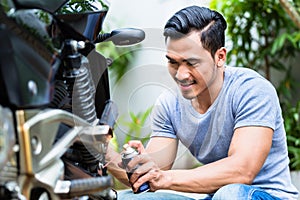 Man spraying grease in the motorbike photo