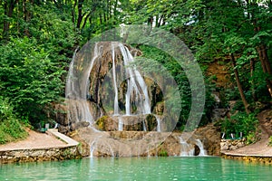 Lucansky waterfall in the village of Lucky - water flows down a travertine rock from a small height among greenery.