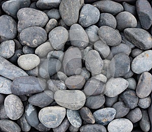 Lucido Nero black natural pebble background. Texture of black smooth stones. Natural pebbles for landscaping photo