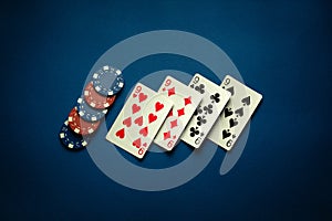 Luck in a casino game with a winning combination of four of a kind or quads. Playing cards nines and chips are laid out in a poker photo