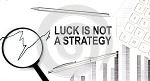 Luck is not a strategy text on document with pen,graph and magnifier,calculator