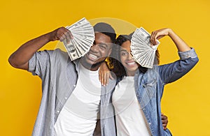 Lucky black man and woman holding lots of dollar cash