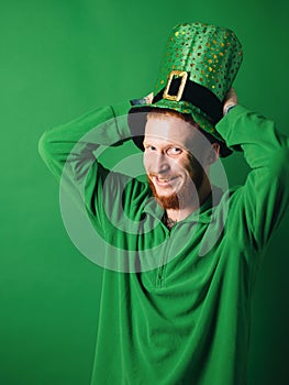 Lucky charms on green background. Man on green background celebrate St Patricks Day. Man in Patrick& x27;s suit smiling.