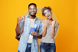 Lucky Couple Holding Flying Tickets Over Yellow Background