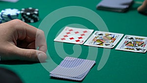 Lucky gambler checking cards, winning combination in poker, ace-high straight