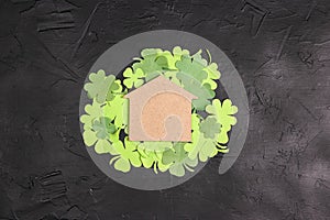Lucky home symbol with four-leaf clover on black background . Copy space for text