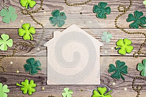 Lucky home symbol with four-leaf clover on wooden background. Co