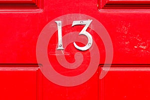 House number 13 on a red wooden front door photo