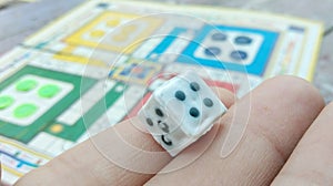 Ludo game board with dice on hand